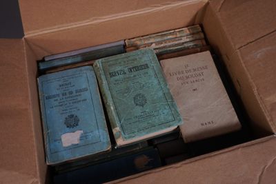 de nombreux livres dans une boîte en carton posée sur une table