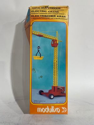 une boîte sur laquelle est représentée une grue jouet qui se trouve à l'intérieur de la boîte