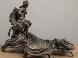 a statue of a woman sitting on top of a chair