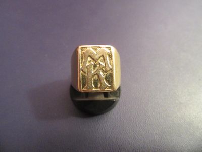 une bague en or ornée d'un motif sur un fond violet