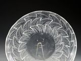 une image représentant une plaque de verre transparent posée sur un socle, sur fond noir
