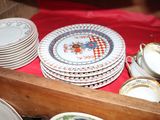 many plates and cups sitting on a red table cloth