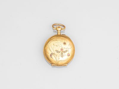 l'image d'une montre de poche en or posée sur une surface blanche