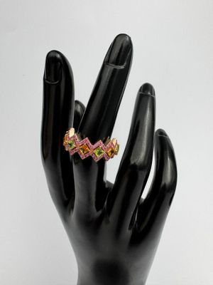 bague en zigzag rose et jaune sur la main d'un mannequin noir