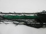 a green pen sitting on top of a pile of black string