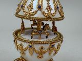 a white and gold box with a carousel on top of it