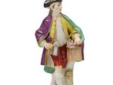 deux figurines représentant un homme avec un panier et un chien