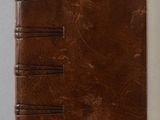 un carnet en cuir marron sur lequel est posé un marque-page