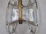 a glass bowl with a gold handle on a white surface