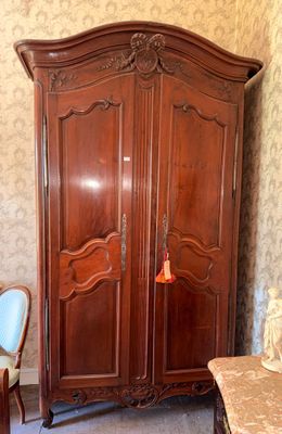 a large wooden armoire in the corner of a room