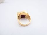 an image of a gold ring with a garnet stone in it