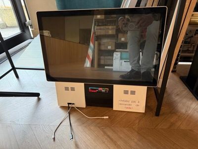 un téléviseur posé par terre devant une fenêtre