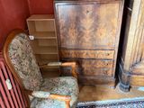 a chair that is next to a dresser in a room