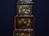 three black and gold painted boxes stacked on top of each other