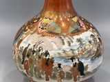a vase with a painting on it on a table
