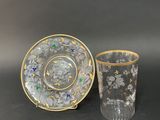 a close up of a glass cup and saucer on a table