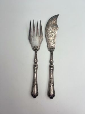 deux fourchettes et un couteau sur une surface blanche