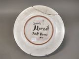 a white plate with a brown rim and writing on it