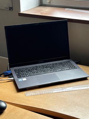 a laptop computer sitting on a desk next to a mouse