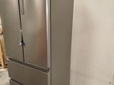 a silver refrigerator sitting on a pallet in a warehouse