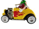 une petite voiture jaune et rouge sur laquelle est assis un homme portant un casque vert