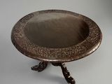 an antique silver plate on a stand on a gray background