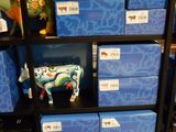 Des boîtes sont empilées sur une étagère dans un magasin où se trouve une figurine de vache