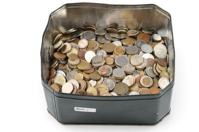 un récipient métallique rempli de pièces de monnaie posé sur une surface blanche