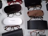 plusieurs paires de lunettes posées sur une table, à côté d'une paire de chaussures