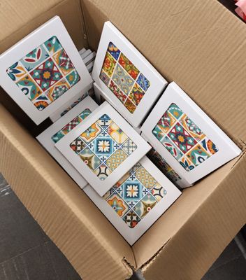 des boîtes de carreaux sont empilées les unes sur les autres dans un carton