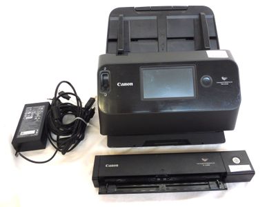 une imprimante Canon et un chargeur posés sur une table