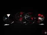 trois paires de boucles d'oreilles en verre rouge et blanc posées sur un fond noir