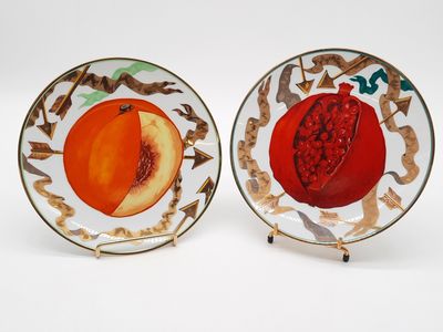 deux assiettes ornées de fruits, posées sur une surface blanche