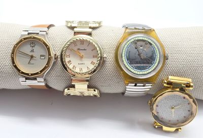 trois montres différentes sont posées sur une serviette, sur une surface blanche