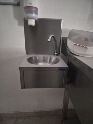 a sink and a soap dispenser in a public bathroom