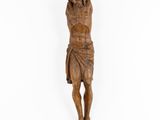 a wooden statue of jesus hanging on a white wall