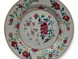 a plate with a floral design on it on a stand