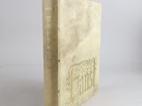 an old book sitting on top of a white table next to a white wall