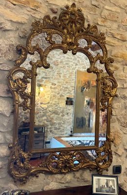 un miroir accroché au mur au-dessus d'une table sur laquelle se trouve un vase