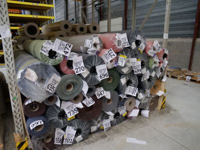 a large pile of rolls of fabric in a warehouse