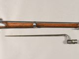 un vieux fusil au canon en bois, représenté sur un fond blanc