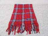 red and blue plaid scarf with fringes on a white surface