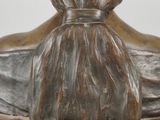 statue of a woman with a hat on her head on a wooden base