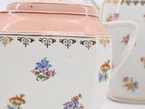 two teapots that are sitting on a white table