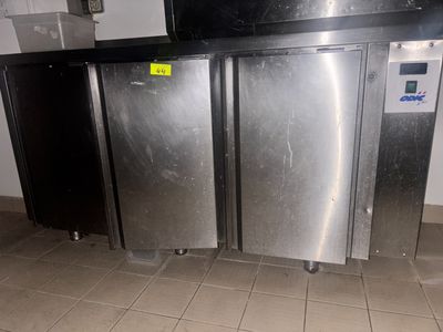 trois réfrigérateurs en acier inoxydable dans une cuisine au sol carrelé