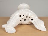 a white ceramic figurine of a bird on a table