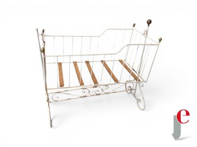 a white iron bed with wooden slats on it