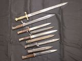 several knives are lined up on a black cloth on a table