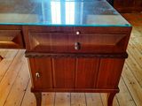 a small desk with a glass top on a wooden floor