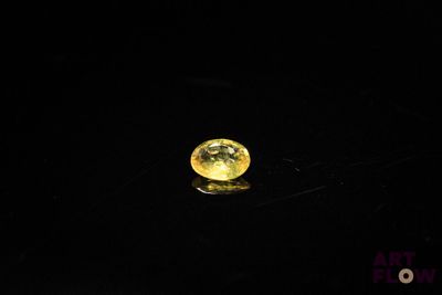 a close up of a yellow diamond on a black surface